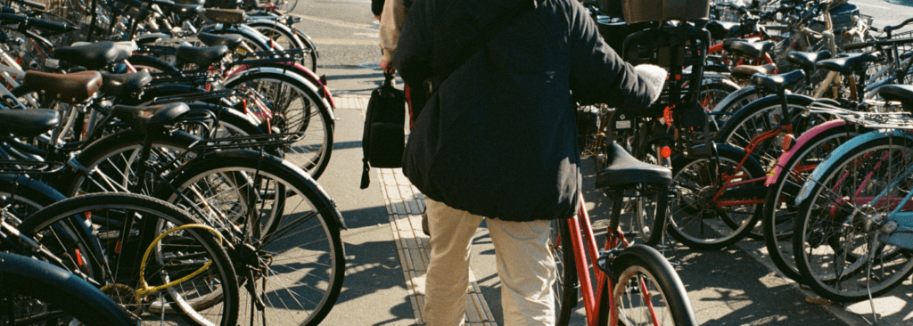 Person with a bike facing away, with racks of bikes on either side