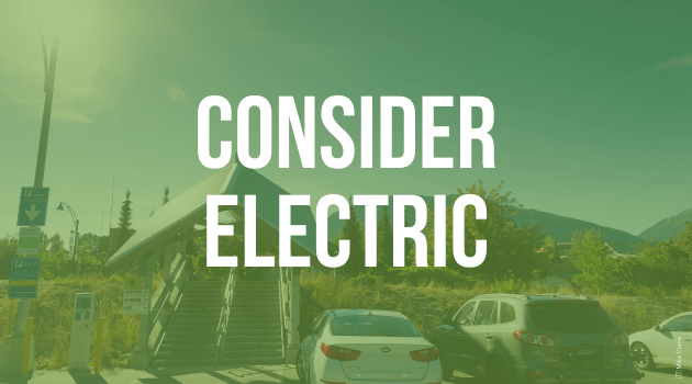 A graphic with text, the image is of a carpark, with an electric charging station and the text reads "Consider electric"