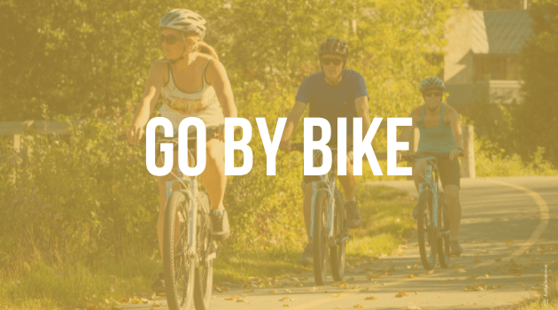 A graphic with text, the image is of three people in a line biking towards the viewer, the text reads "Go By Bike"